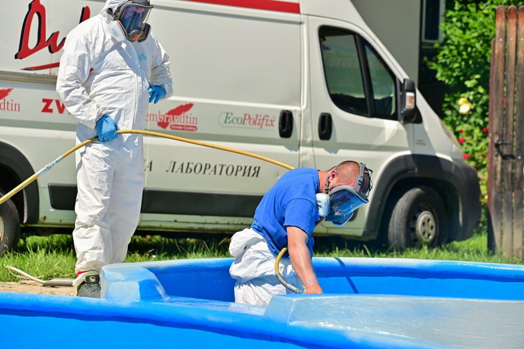 Двама мъже използват DIXIPRO, за да работят върху син басейн.